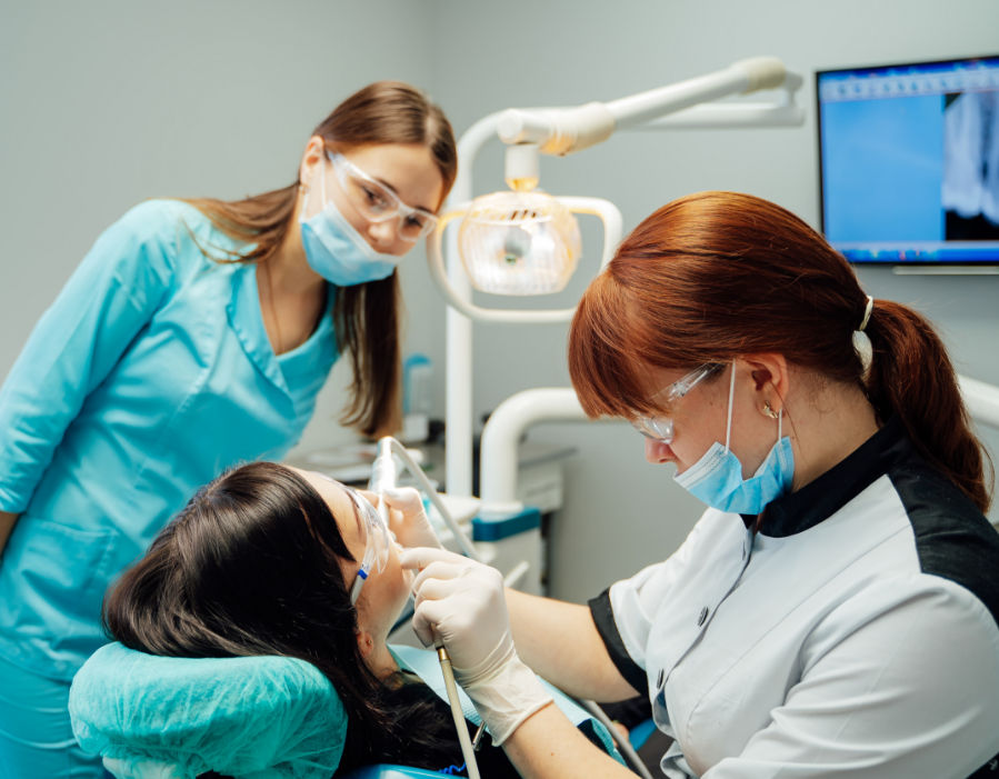 female patient getting an dental exam by the dentist and hygienist
