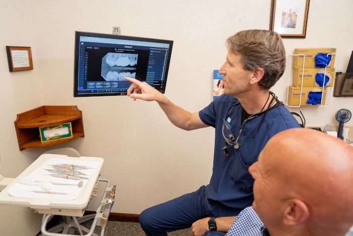 Dr. Almoney with a male patient showing dental X-rays in Dayton, OH
