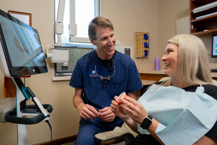 Dr. William Almoney with a female patient in a dental chair