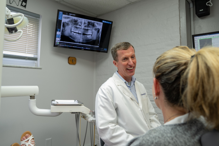 Gerald D. Brown, DDS explaining X-rays to a female patient